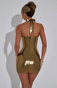 Detail of the backless gold metallic halter dress featuring a bow tie and invisible zipper
