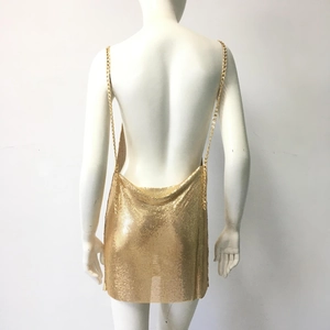 Détail de la mini robe en maille dorée avec dos nu et fines bretelles en chaîne métal