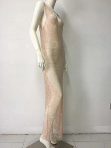 Dettaglio macro dell'abito da sera a rete oro rosa con strass luccicanti e trama traforata