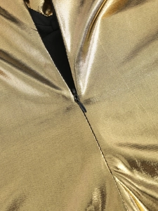 Detail of invisible black zipper on metallic gold coated fabric with fine stitching