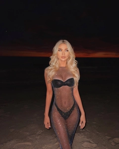 Detail of sheer black mesh dress with shimmering rhinestones over bikini at the beach