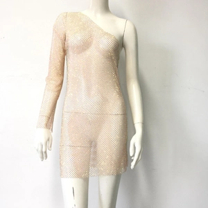 Détail de la robe en maille champagne avec strass scintillants et manche asymétrique élégante