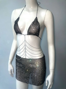Detailed view of black rhinestone mesh bikini top and matching mini skirt with waist chains
