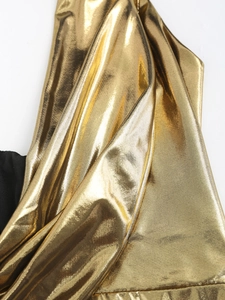 Close-up of shimmering metallic gold fabric with elegant draped texture and luxury silk sheen