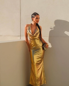 Detail of gold metallic halter neck dress with deep V-neckline and reflective finish