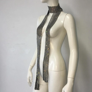 Détail d'une écharpe en maille grise avec strass colorés et franges métalliques