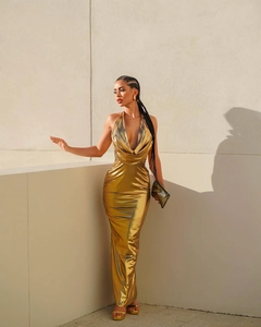 Detail of metallic gold halter neck maxi dress with a deep V-neck and a slim fit cut