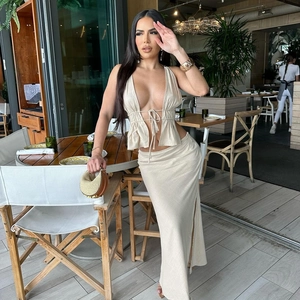 Detail of beige two-piece set featuring deep V-neck tie top and high-slit long skirt