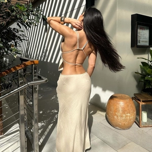 Detail of cream backless halter top with crossover straps and satin maxi skirt