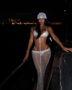 Détail du haut de bikini à paillettes blanches et de la jupe longue en résille de fête