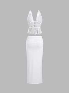 Detail of white two-piece set featuring halter neck tie-top and ruched bodycon maxi skirt