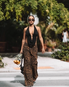 Détail du haut dos nu noir à col en V avec un pantalon large à imprimé léopard chic