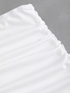Macro shot of white ribbed knit fabric featuring detailed ruching and stitching