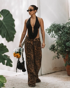 Détail d'un top dos nu noir porté avec un pantalon large à imprimé léopard