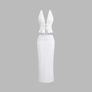 Detailed close-up of white two-piece set featuring halter neck top and ruched high waist skirt
