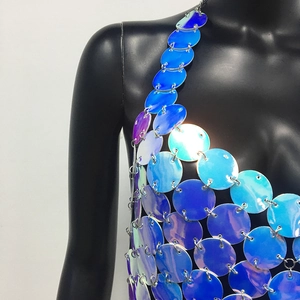 Dettaglio di paillettes olografiche blu e viola collegate da anelli metallici per gilet