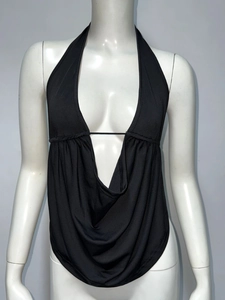Détail du haut dos nu noir avec décolleté en V profond et tissu drapé sur un mannequin