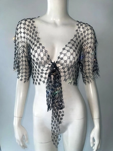 Detail of black mesh V-neck top with sparkling rhinestones and long fringe tassels