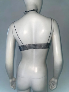 Détail d'un haut sexy en résille noire avec strass brillants et fines bretelles