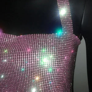 Dettaglio del top a rete con strass rosa e cristalli scintillanti su un manichino nero