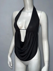 Détail d'un haut licou noir avec décolleté en V profond et texture de tissu drapé