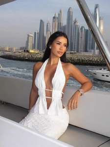 Sexy white halter neck two-piece set with deep V-neck and hollow waist on luxury yacht
