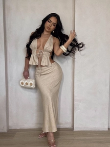 Elegant two-piece beige linen set featuring halter neck top and high-waisted maxi skirt