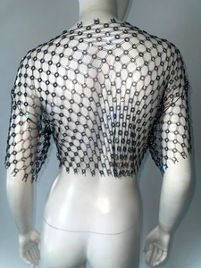 Detail of black hollow fishnet top with rhinestone floral patterns for music festivals