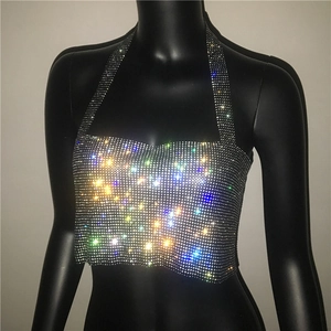 Dettaglio di un crop top con strass colorati su tessuto nero elastico per look da festa