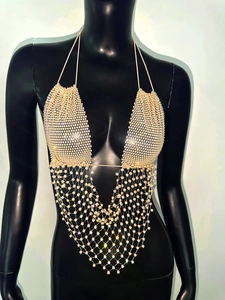 Dettaglio del top all'americana in rete di strass oro champagne con nappe su manichino