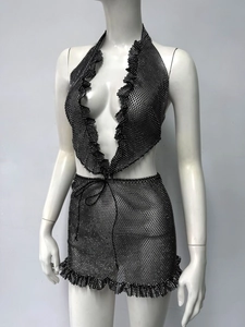Détail de l'ensemble noir en maille strass avec haut dos nu et jupe à ourlet volanté