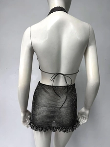 Détail d'un ensemble deux pièces en maille strassée noire avec haut dos nu et mini-jupe