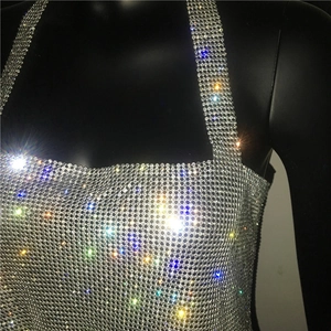 Dettaglio ravvicinato del tessuto in rete con strass argento scintillanti di un top metallico