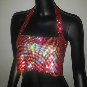 Dettaglio degli strass rossi scintillanti sul top sexy a fascia con allacciatura al collo