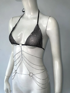 Dettaglio del top all'americana in rete con strass e catena corpo in argento