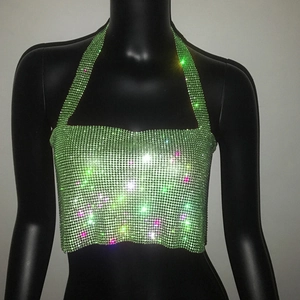 Détail du haut dos nu vert fluo avec strass étincelants et maille métallique en cristal