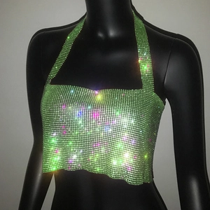 Dettaglio ravvicinato di un top halter con strass verde scintillante su un manichino nero