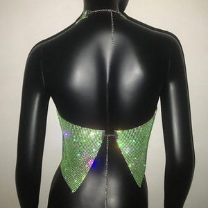 Dettaglio del top a lupetto verde neon in maglia metallica e strass con catene retro