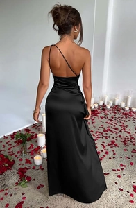 Detail of elegant black satin backless dress with side drapery on a rose petal floor