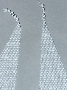 Detail of white beaded mesh top with sparkling rhinestones and halter neck strap