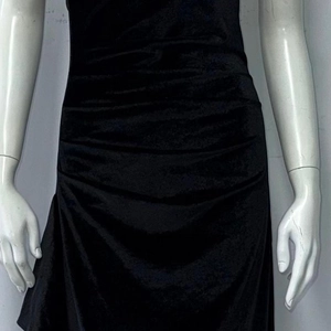 Detail of waist ruching on black velvet dress showing slim fit texture and fabric sheen