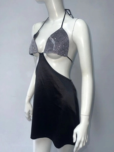 Detail of sequin halter top and black satin mini skirt with cut-out waist design