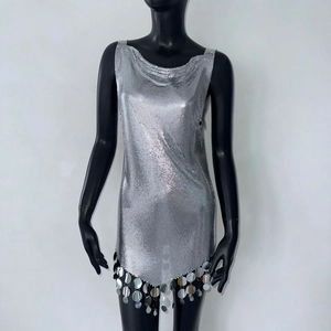 Détail de robe à paillettes argentées avec col bénitier et ourlet à grands disques miroirs