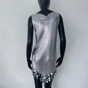 Détail de robe en maille métallique argentée avec paillettes et franges pendantes