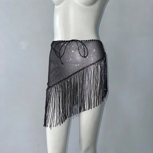 Détail d'une jupe en résille noire à strass avec de longues franges et ourlet irrégulier