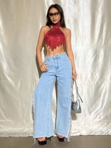 Detail eines roten Pailletten-Neckholder-Tops mit Fransendenim-Jeans mit weitem Bein