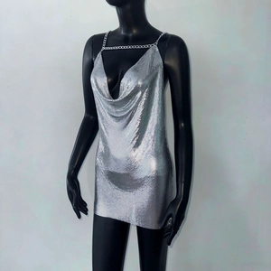 Detailed view of shimmering silver chainmail fabric and thin metallic straps on party dress