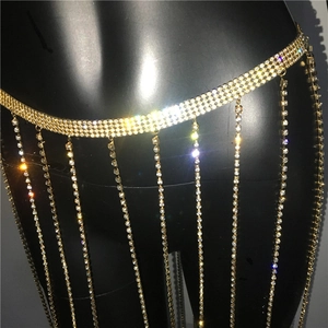 Detail einer schimmernden goldenen Strass-Quasten-Körperkette auf einer schwarzen Modepuppe