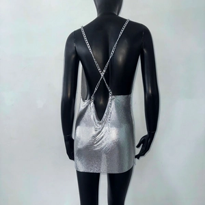 Detail of silver metallic mesh mini dress with crisscross chain straps and backless design
