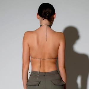 Détail du haut dos nu à paillettes argentées avec fines chaînes métalliques